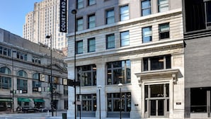 A multi-story building with a classical architectural style, featuring large windows and a prominent entrance with a sign above. - Courtyard by Marriott Cincinnati Downtown (Cincinnati)