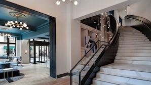 A modern interior with a curved staircase, wooden flooring, and contemporary lighting fixtures. - Courtyard by Marriott Cincinnati Downtown (Cincinnati)