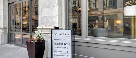 A signboard with parking rates for a Courtyard by Marriott hotel.