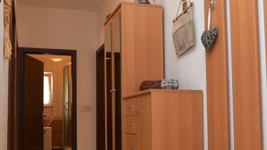 A hallway with wooden cabinets, a wicker basket, and a mirror on the wall.