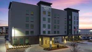 A modern hotel with a prominent sign reading "Homewood Suites by Hilton".