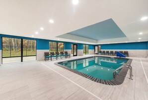 Una piscina techada, sillones reclinables de piscina