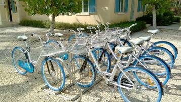 Uma fileira de bicicletas estacionadas em frente a um edifício com persianas azuis.