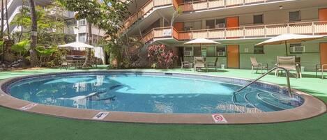 Una piscina al aire libre, sillones reclinables de piscina