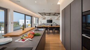 Una cucina moderna con una grande isola, una zona pranzo e vista sulla città.