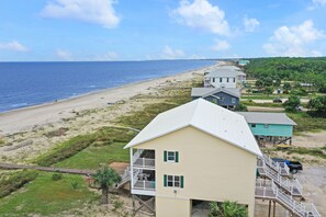 A coastal property with a two-story building featuring a balcony and a view of the beach. - Beach front, updated townhome in Indian Pass~ Pelican Landing 2 (Indian Pass)