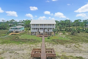 A two-story building with a central walkway leading to a dock. - Beach front, updated townhome in Indian Pass~ Pelican Landing 2 (Indian Pass)