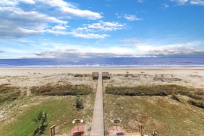 A beach view with a wooden boardwalk leading to beach chairs and umbrellas. - Beach front, updated townhome in Indian Pass~ Pelican Landing 2 (Indian Pass)