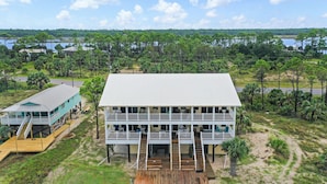 A two-story waterfront building with a dock, surrounded by a natural landscape and a lake. - Beach front, updated townhome in Indian Pass~ Pelican Landing 2 (Indian Pass)