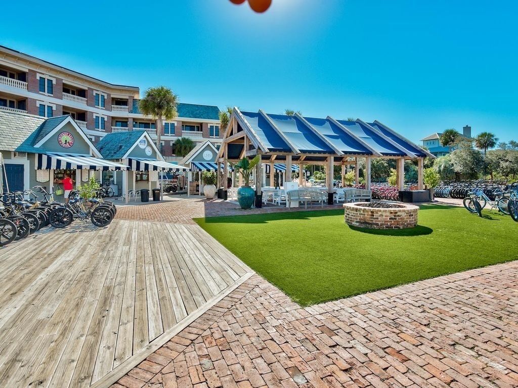 Un resort con varias edificaciones, zonas de estar al aire libre y un camino pavimentado.