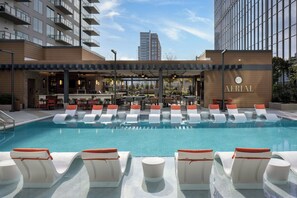 Una piscina al aire libre, cabañas de piscina (de pago), tumbonas
