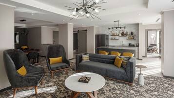 A modern living room with grey sofas, yellow cushions, and a round coffee table.