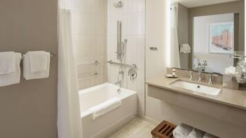 A modern bathroom with a bathtub, a shower, and a vanity with a mirror.