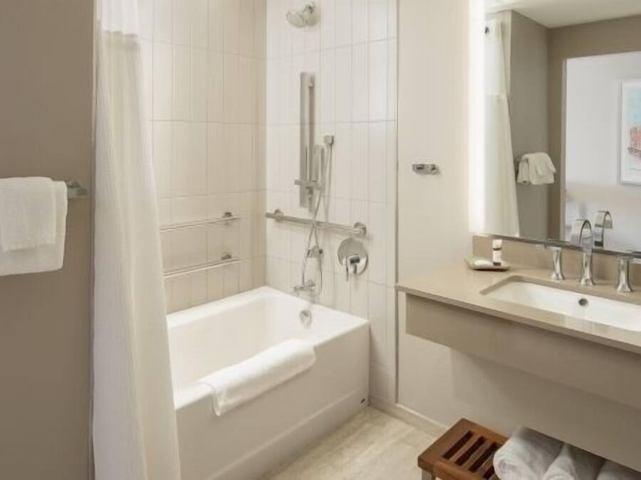 A modern bathroom with a bathtub, a shower, and a vanity with a mirror.