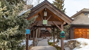 Une passerelle couverte en bois mène à un bâtiment sur lequel est affiché un panneau indiquant le nombre d’unités disponibles.