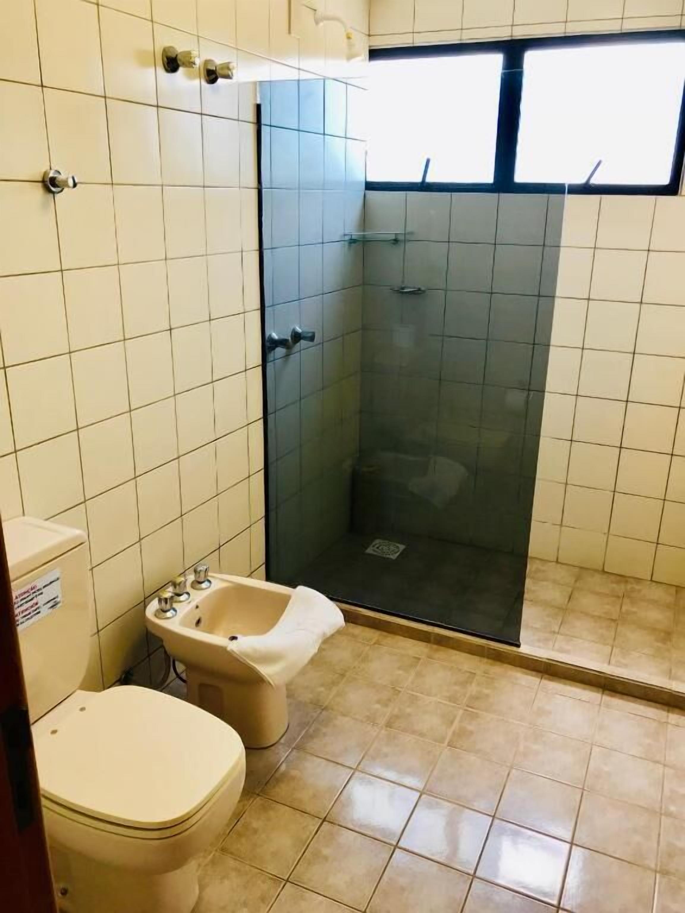 Ein Badezimmer mit Toilette, Bidet und einer Duschkabine.