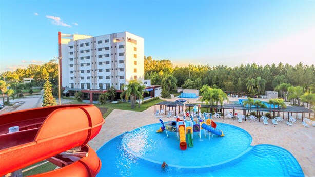 A hotel with a pool area featuring a water slide and a children's play area. - Hotel San Isidro (Sao Gabriel)