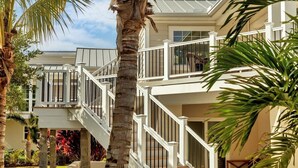 A multi-story house with a balcony, palm trees, and a clear sky. - Manasota Key Dock house - Stunning Bayfront with private beach access for the perfect vacation (Englewood)