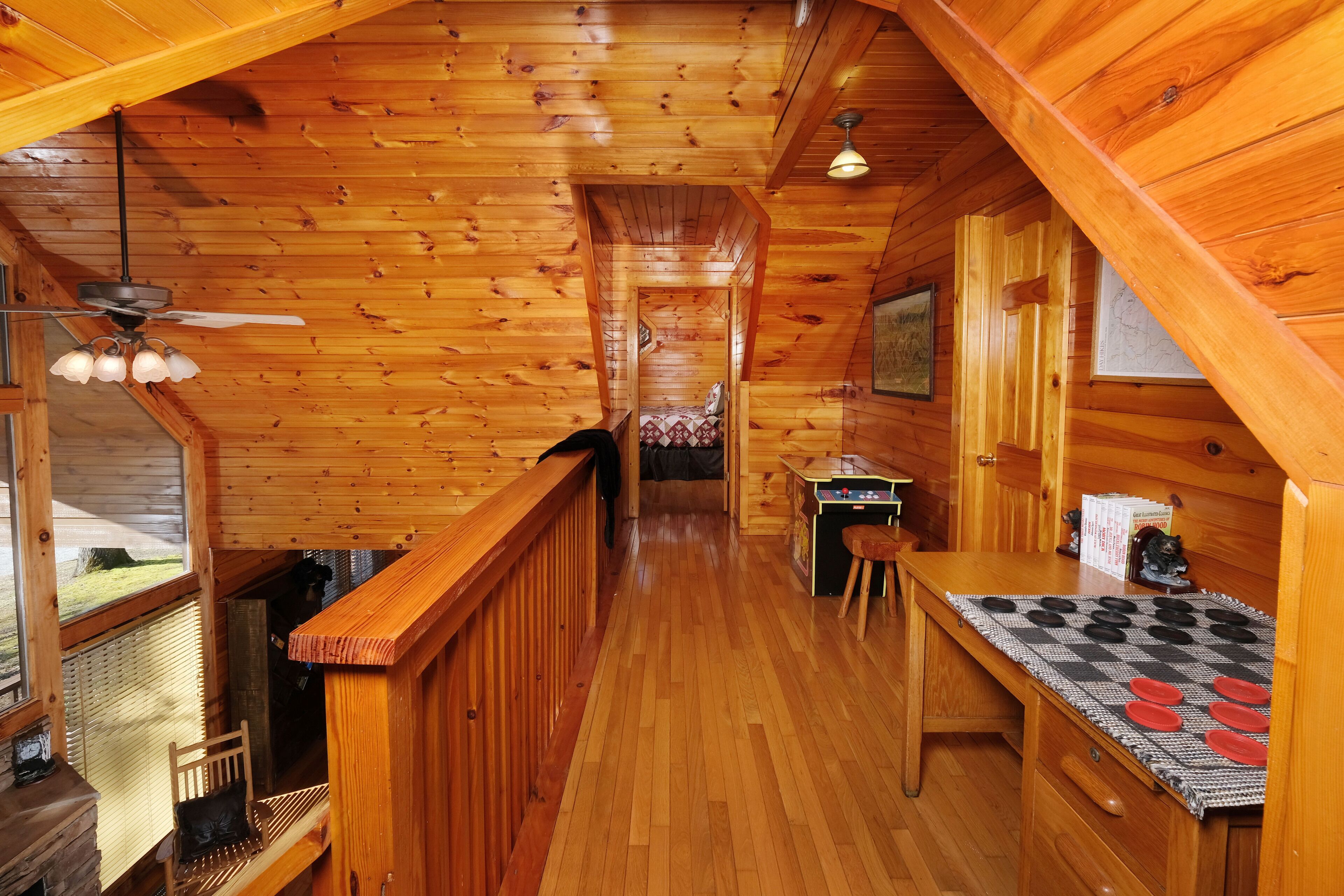 A wooden interior with a kitchen area, a dining table, and a bench.