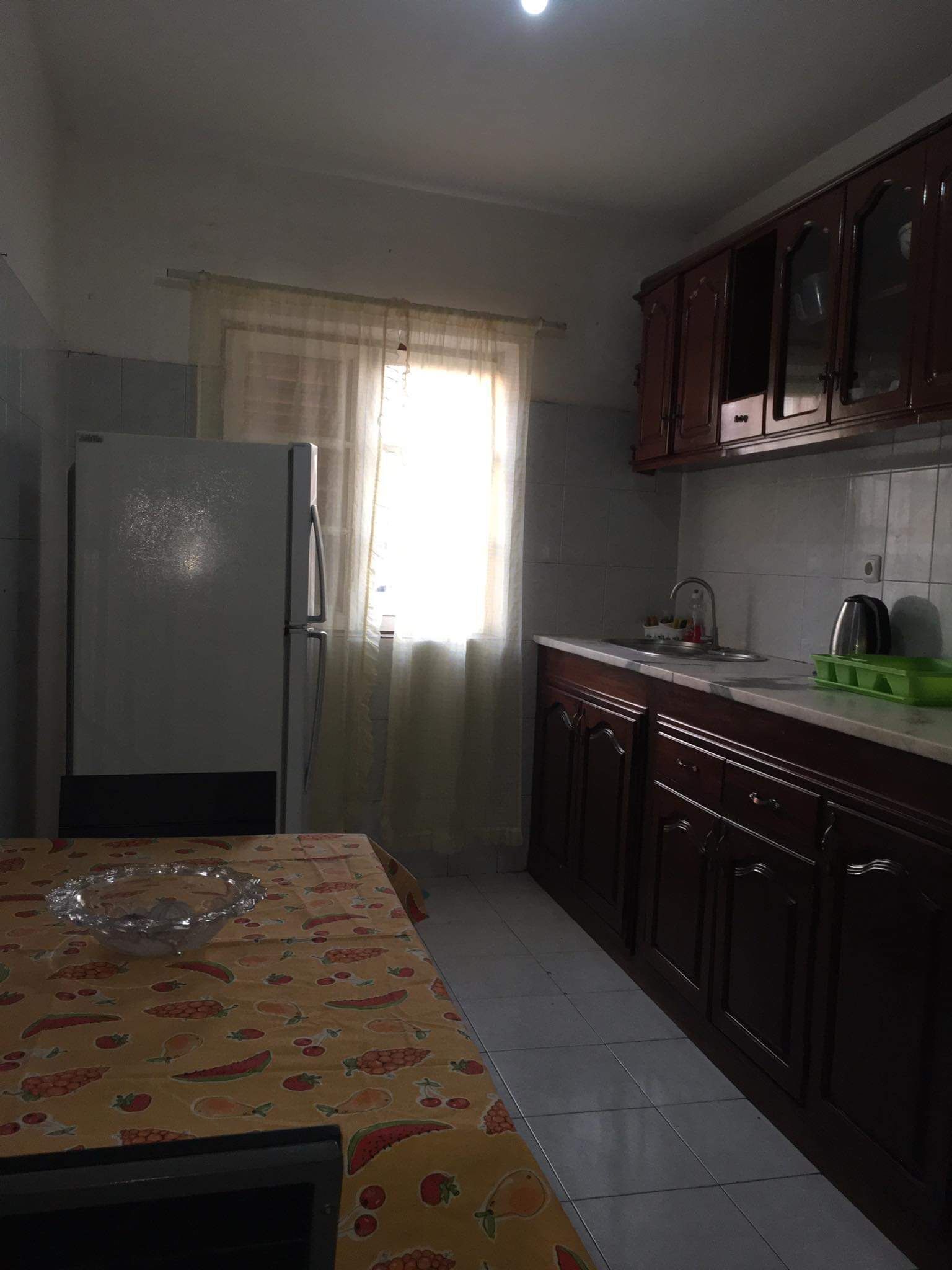 Uma cozinha com geladeira, pia e armários.