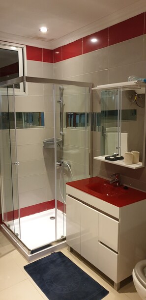 Tina con regadera, toallas, papel de baño