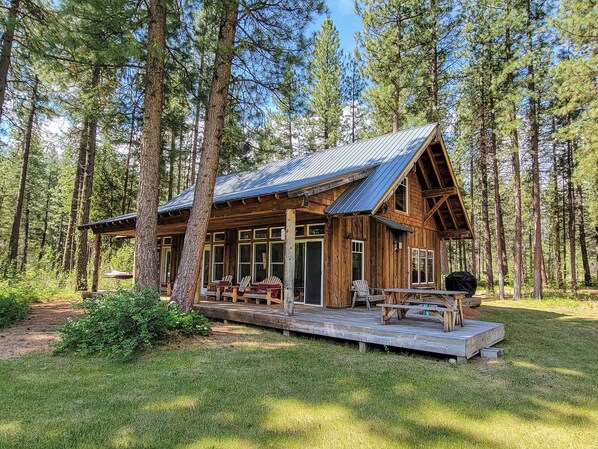 Enjoy the serene forest views from the deck with seating and barbecue area.