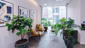 A modern interior with a seating area, potted plants, and artwork on the walls.
