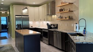 A modern kitchen with a central island, stainless steel appliances, and built-in cabinetry. - Traverse City, West side of downtown, Sleeps 6, Slabtown area (Traverse City)