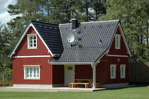 A red house with a sloped roof, a satellite dish, and a small porch with benches. - Cottage Faflik - Air Con And Own Sauna, Swedish House no 001 (Vlkov)