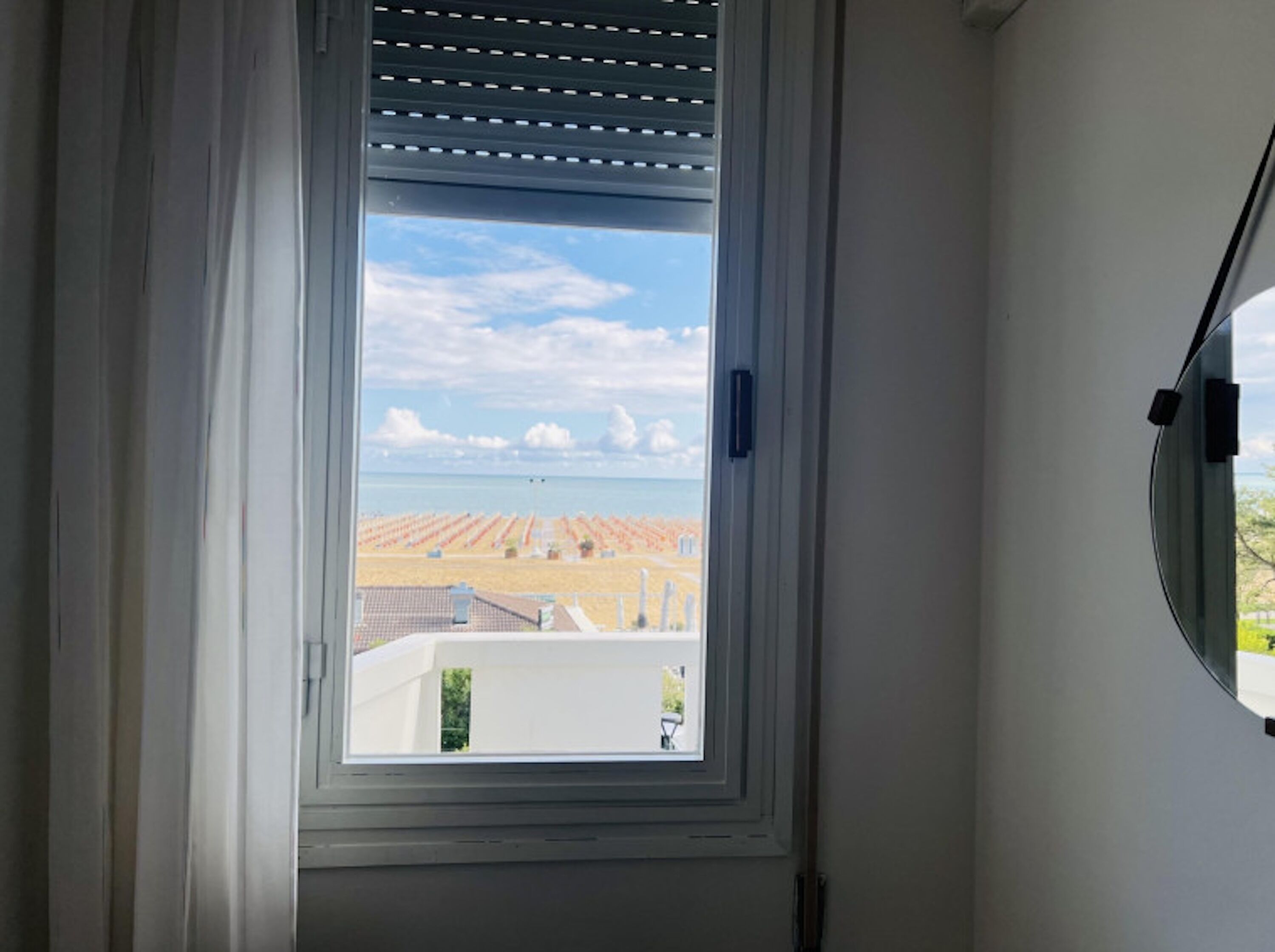 A window with a view of a beach and solar panels.