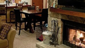 Un salon doté d’une cheminée, d’un téléviseur et d’un coin repas agrémenté d’un lustre.