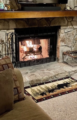Cozy living room with a fireplace, sofa, and decorative rug.