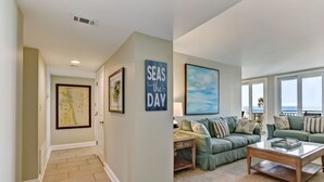 A living room with a green sofa, a coffee table, and a painting on the wall. - Sunkissed Escape with spectacular views (Fernandina Beach)