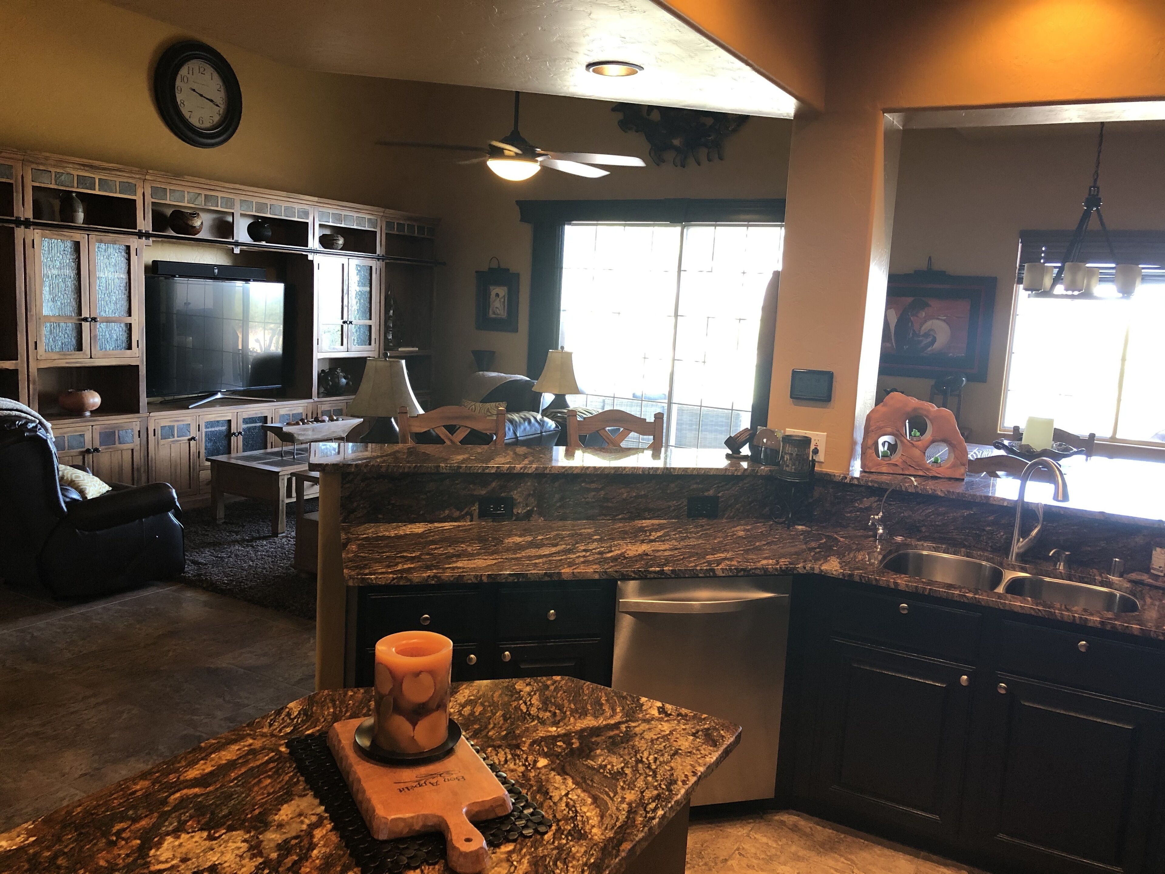 A modern kitchen with granite countertops, a built-in dishwasher, and a large window providing natural light.