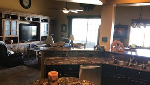 A modern kitchen with granite countertops, a built-in dishwasher, and a large window providing natural light. - Southwestern Patio Home-Magnificent Mountain Views (Oro Valley)