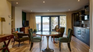 A modern kitchen with a dining area, large windows, and a view of the outdoors. - Tarn End Cottage 8, Talkin Tarn, Brampton ideal for a romantic break overlooking the Tarn (BRAMPTON)