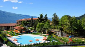 A resort with a swimming pool, sun loungers, and a playground.