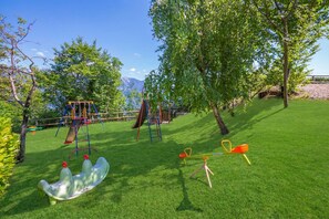 A playground with swings, a slide, and a seesaw.