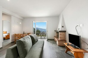 Ein modernes Wohnzimmer mit einer Couch, einem Fernseher auf einem Holzboden und einem Kamin.
