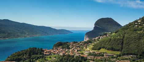 A coastal town with buildings on a hillside overlooking a lake.