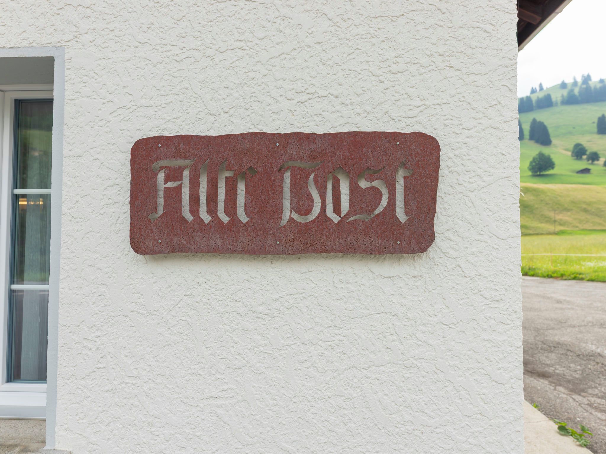 A sign with the text 'Fin Bost' mounted on a white wall.