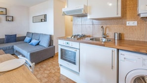 A compact kitchen with a built-in oven, a sink, and a dishwasher. - Les terrasses de la Plage by Interhome (Cap d'Agde)