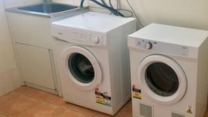 A laundry area with two washing machines and a sink. - Spacious townhouse located in the CBD! (East Wagga Wagga)