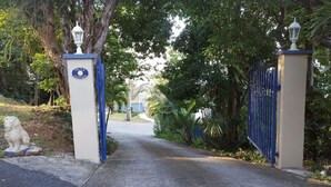 A gated entrance with a sign reading "Villa Indigo" and a statue of a lion.