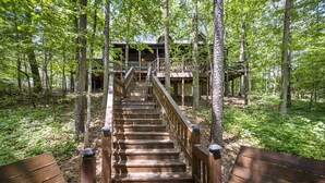 A wooden staircase leading to a cabin in a forest.