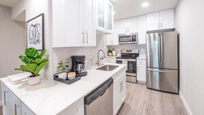A modern kitchen with white cabinets, stainless steel appliances, a dishwasher, and a coffee maker. - BRAND NEW FULL LUXURY REMODEL - Old Town Scottsdale! 2BR/2BA En-suite, Htd Pool! (Scottsdale)