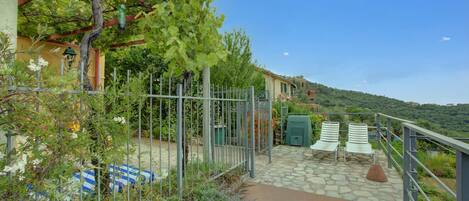 A garden with a pergola, a stone pathway, and outdoor seating.