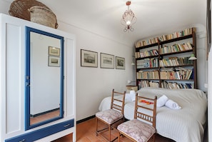 A bedroom with a bed, two chairs, a bookshelf, and a mirror. - Ca Veggia for Nature Lovers With Views & Garden (Stellanello)