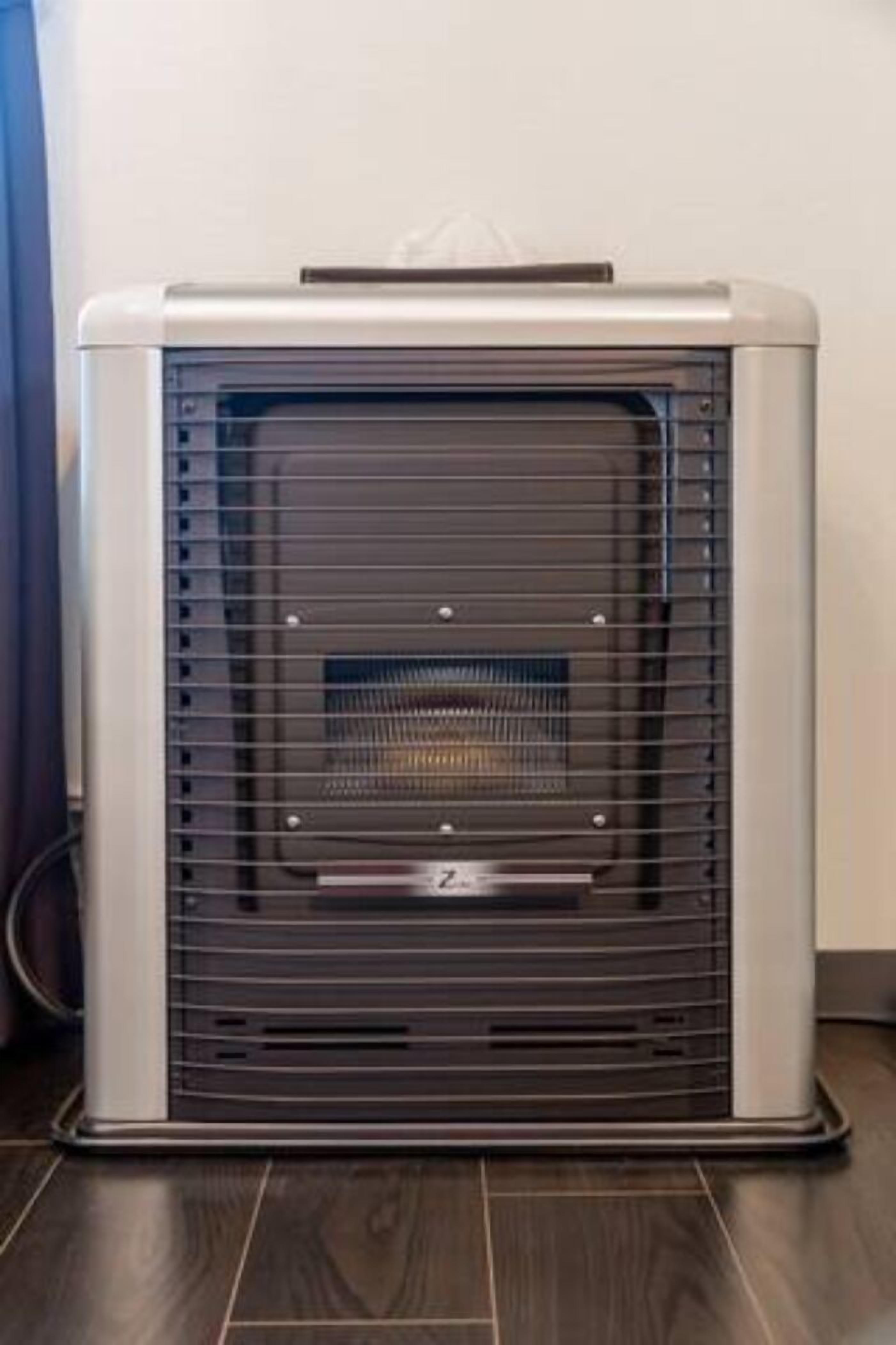 A portable heater with a front vent and a control panel on top.