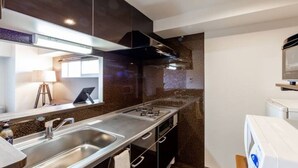 A modern kitchen with stainless steel appliances, a built-in oven, and a microwave. - Diva (Sapporo)